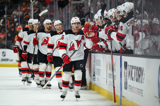 New Jersey Devils center Jack Hughes, center, greets teammates after scoring during the third period of an NHL hockey game against the Anaheim Ducks Sunday, Nov. 2, 2025, in Anaheim, Calif. (AP Photo/William Liang)