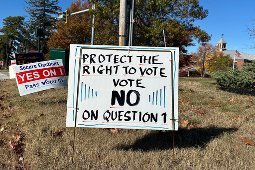 Signs supporting and opposing a voter identification referendum in the state are shown Thursday, Oct. 23, 2025, in Scarborough, Maine. (AP Photo/Patrick Whittle)