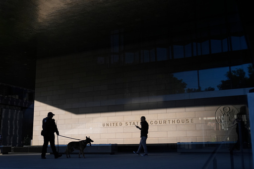 FILE - A police officer inspects the exterior of a federal courthouse with the aid of a canine on Sept. 5, 2024, in Los Angeles. (AP Photo/Jae C. Hong, File)