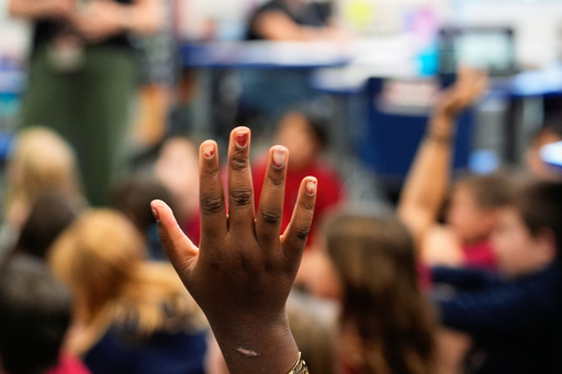 FILE - A student raises her hand at A.D. Henderson School in Boca Raton, Fla., April 16, 2024. (AP Photo/Rebecca Blackwell, File)