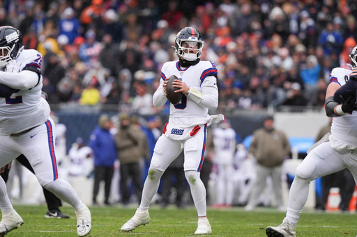 New York Giants quarterback Jaxson Dart, center, looks to throw during the first half of an NFL football game against the Chicago Bears, Sunday, Nov. 9, 2025, in Chicago. (AP Photo/Nam Y. Huh)