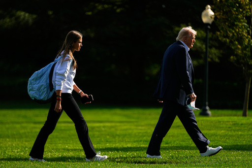 FILE - President Donald Trump, right, arrives with his granddaughter Kai Trump at the White House, Friday, Sept. 26, 2025, in Washington. (AP Photo/Julia Demaree Nikhinson, file)