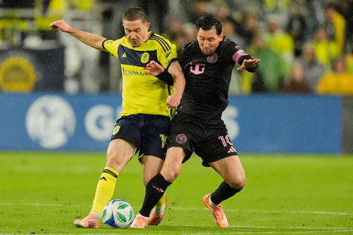 Nashville SC midfielder Alex Muyl, left, and Inter Miami forward Lionel Messi, right, battle for the ball during the first half of Game 2 in the first round of MLS soccer Eastern Conference playoff Saturday, Nov. 1, 2025, in Nashville, Tenn. (AP Photo/George Walker IV)
