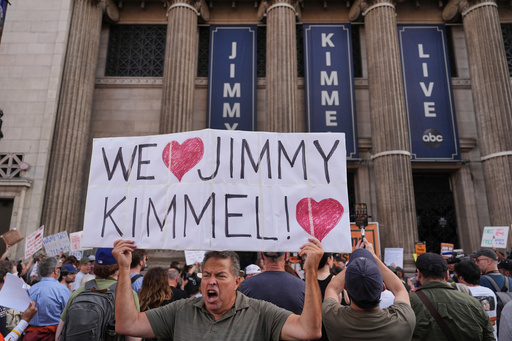 FILE - Oscar Villanueva holds a sign outside El Capitan Entertainment Centre, where the late-night show "Jimmy Kimmel Live!" is staged, Sept. 18, 2025, in Los Angeles. (AP Photo/Jae C. Hong, File)