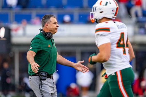 Miami head coach Mario Cristobal greets players as they come off the field during the first half of an NCAA college football game against SMU, Saturday, Nov. 1, 2025, in Dallas. (AP Photo/Jeffrey McWhorter)