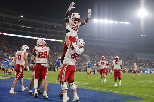 Nebraska running back Emmett Johnson (21) is lifted into the air by Nebraska linebacker Christian Jones (50) after Nebraska scored a touchdown against UCLA during the second half of an NCAA college football game Saturday, Nov. 8, 2025, in Pasadena, Calif. (AP Photo/Ethan Swope)