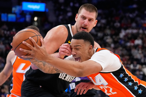 Los Angeles Clippers guard Jordan Miller, right, drives past Denver Nuggets center Nikola Jokic during the second half of an NBA basketball game Wednesday, Nov. 12, 2025, in Inglewood, Calif. (AP Photo/Mark J. Terrill)