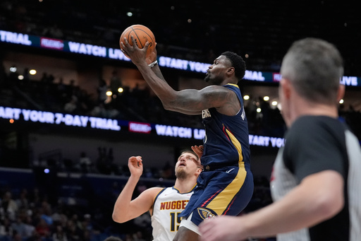 New Orleans Pelicans forward Zion Williamson (1) goes to the basket over Denver Nuggets center Nikola Jokic (15) in the first half of an NBA basketball game, Wednesday, Nov. 19, 2025, in New Orleans. (AP Photo/Gerald Herbert)