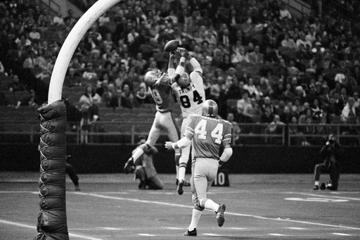 FILE - Cincinnati's tight end Bob Trumpy (84) and Houston's Ken Houston (29) fight for a high pass from Bengals quarterback Sam Wyche in the second quarter of an NFL football game on Dec. 13, 1970 in the Houston Astrodome. Houston Johnny Peacock (44) watches the action. (AP Photo/Ed Kolenovsky, file)
