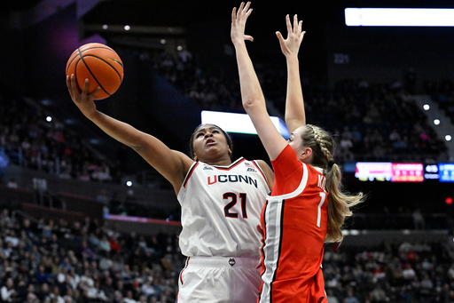 UConn forward Sarah Strong (21) shoots as Ohio State forward Kylee Kitts (1) defends in the first half of an NCAA college basketball game, Sunday, Nov. 16, 2025, in Hartford, Conn. (AP Photo/Jessica Hill)
