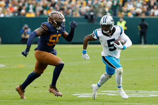 Carolina Panthers running back Rico Dowdle (5) runs against Green Bay Packers defensive end Kingsley Enagbare (55) during the second half of an NFL football game Sunday, Nov. 2, 2025, in Green Bay, Wis. (AP Photo/Mike Roemer)