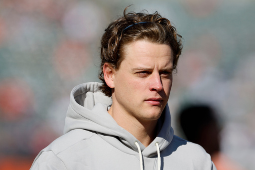 Injured Cincinnati Bengals quarterback Joe Burrow walks on the field before an NFL football game against the New England Patriots, Sunday, Nov. 23, 2025, in Cincinnati. (AP Photo/Jay LaPrete)