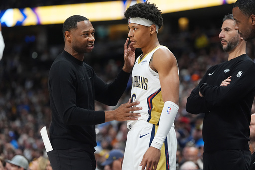 New Orleans Pelicans head coach Willie Green, left, confers with guard Jeremiah Fears, center, as assistant coach James Borrego looks on in the first half of an NBA basketball game against the Denver Nuggets Wednesday, Oct. 29, 2025, in Denver. (AP Photo/David Zalubowski)