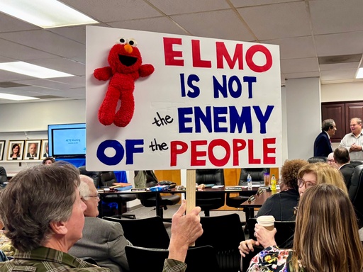 An audience member holds a sign at a meeting of the Alabama Educational Television Commission on Tuesday, Nov. 18, 2025, in Birmingham, Ala. (AP Photo/Kim Chandler)