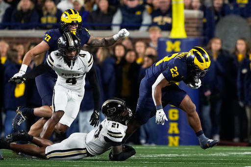 Michigan running back Jordan Marshall (23) is tackled by Purdue defensive back Tahj Ra-El (21) during the first half of an NCAA college football game, Saturday, Nov. 1, 2025, in Ann Arbor, Mich. (AP Photo/Ryan Sun)