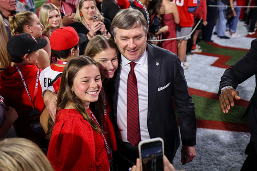 Georgia head coach Kirby Smart poses for a photo with fans before the start of an NCAA college football game against Texas, Saturday, Nov. 15, 2025, in Athens, Ga. (AP Photo/Colin Hubbard)