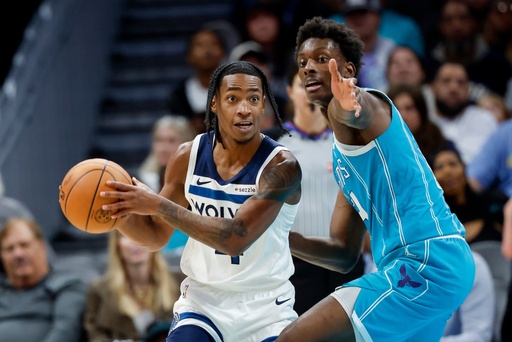 Minnesota Timberwolves guard Rob Dillingham, left, looks to pass against Charlotte Hornets forward Moussa Diabate during the second half of an NBA basketball game in Charlotte, N.C., Saturday, Nov. 1, 2025. (AP Photo/Nell Redmond)
