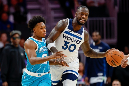 Minnesota Timberwolves forward Julius Randle (30) moves the ball against Charlotte Hornets guard Collin Sexton during the first half of an NBA basketball game in Charlotte, N.C., Saturday, Nov. 1, 2025. (AP Photo/Nell Redmond)