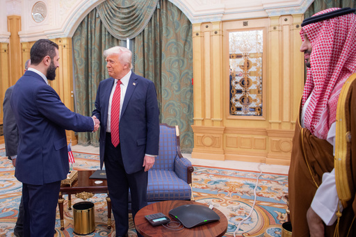 FILE - In this photo provided by the Saudi Royal Palace, Syria's interim President Ahmad al-Sharaa, left, shakes hands with U.S. President Donald Trump in Riyadh, Saudi Arabia, Wednesday, May 14, 2025. At foreground right is Saudi Crown Prince Mohammed bin Salman. (Bandar Aljaloud/Saudi Royal Palace via AP, File)