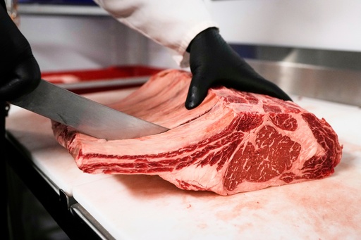 FILE - Raul Rubero, lead butcher at Deep Cuts butcher shop cuts single portions of bone-in steaks as he breaks down a side of beef, Wednesday, Aug. 27, 2025, in Dallas. (AP Photo/Tony Gutierrez, File)