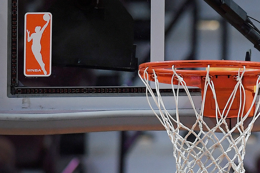 FILE - The WNBA logo is seen near a hoop before an WNBA basketball game at Mohegan Sun Arena, May 14, 2019, in Uncasville, Conn. (AP Photo/Jessica Hill, File)