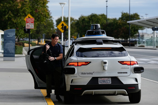 Dan Rowan exits a Waymo vehicle after arriving at San Jose Mineta International Airport, Wednesday, Nov. 12, 2025, in San Jose, Calif. (AP Photo/Godofredo A. Vásquez)